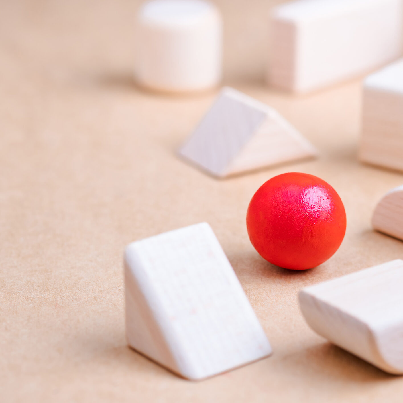 A red ball is in the middle of some white blocks.